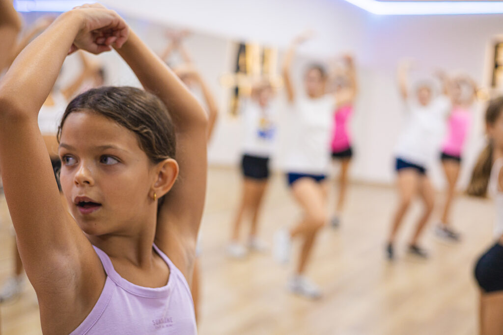 Alumna practicando un movimiento de brazos en clase de danza en FAMA