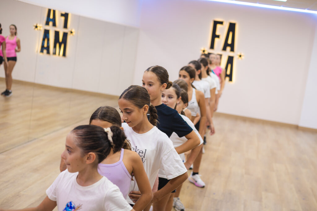 Alumnas de FAMA practicando pasos de baile en formación, una detrás de otra