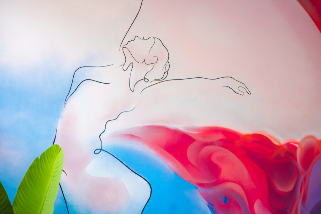 Mural de una bailarina con colores rosas, azules y amarillos en la sala de FAMA