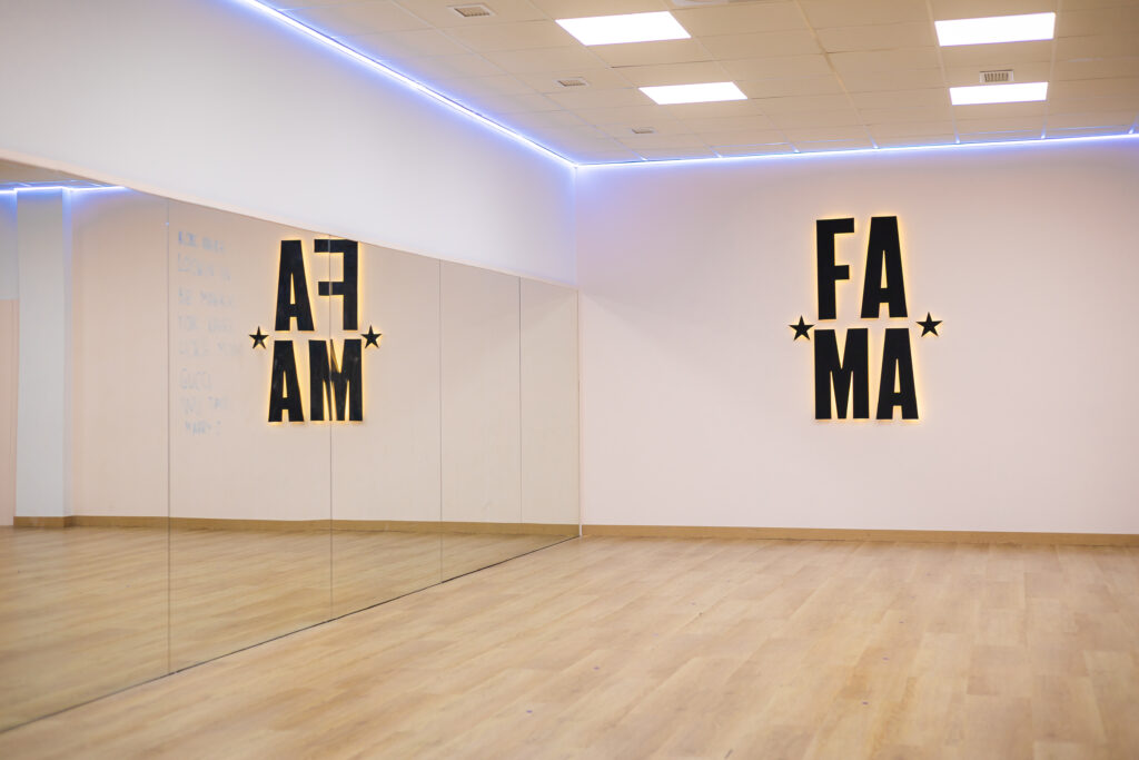 Sala de baile de FAMA en Molina de Segura, con suelo de madera, espejos y el logotipo de la academia